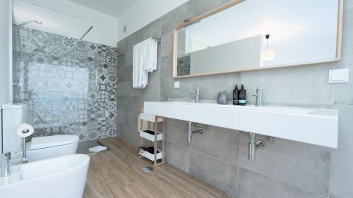 a bathroom with a white sink and a toilet at Villa Calhau by LovelyStay in Ponta do Sol