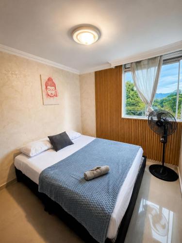 a bedroom with a bed with a shoe on it at Espectacular Apto in Ibagué