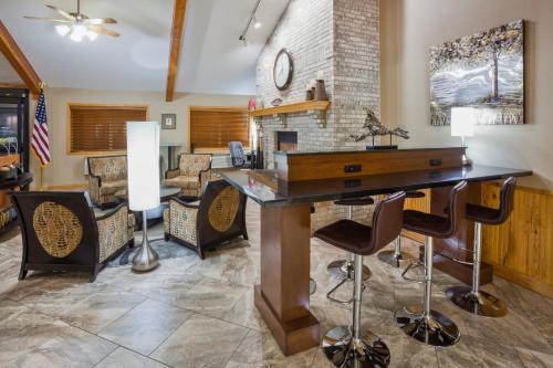 a kitchen with a desk and chairs in a room at AmericInn by Wyndham Sartell in Sartell