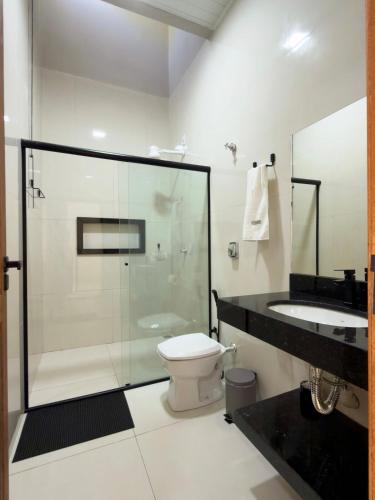 a bathroom with a shower and a toilet and a sink at Casa 02 - Aconchegante e cheia de estilo - 5 min do centro in Alta Floresta