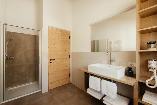 a bathroom with a sink and a shower at New - Penthouse Zirm Untermairhof in Selva dei Molini