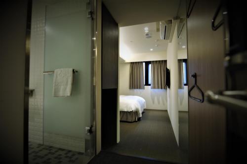 a bathroom with a shower and a bed at Ours Inn in Taipei