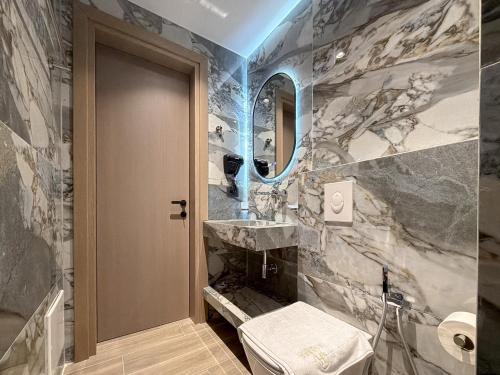 a bathroom with a sink and a toilet and a mirror at Hotel Olserd in Ksamil