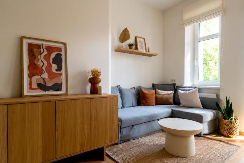 a living room with a couch and a table at Historic Karaimai Street Balcony Apartment, Trakai, Lithuania in Trakai