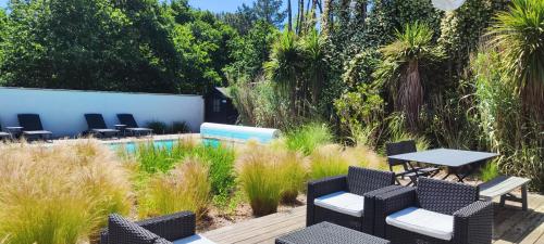 a patio with chairs and a table and a pool at B&B Les Villas de Gascogne in Lanton