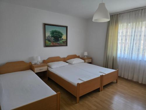 a hotel room with two beds and a window at Apartment Kristijan in Pag