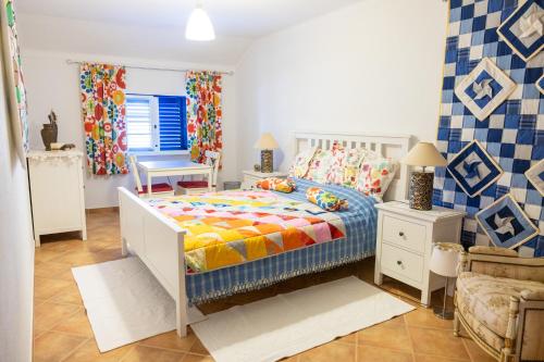 a bedroom with a bed and a chair at Casa de Sume in Monte da Pedra