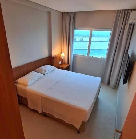 a bedroom with a white bed and a window at Salinas Exclusive Resort in Salinópolis
