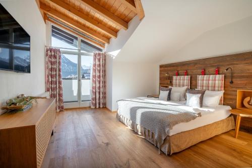 a bedroom with a bed and a large window at Hotel Franks in Oberstdorf