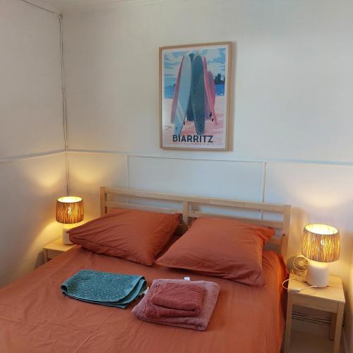 a bedroom with a bed with two towels on it at Les canaris in Mimizan-Plage