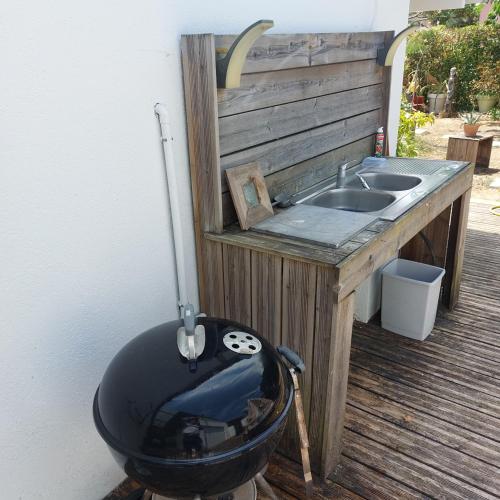 a grill sitting next to a sink on a deck at Les canaris in Mimizan-Plage
