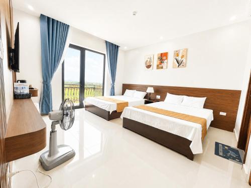 a hotel room with two beds and a balcony at TRƯỜNG THỊNH Hotel in Hòn Tru