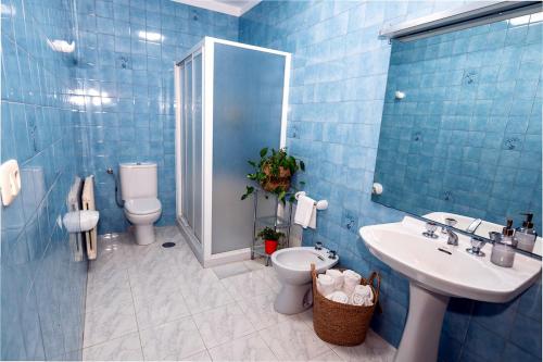 a blue bathroom with a toilet and a sink at Casa Maruja O Grove in O Grove