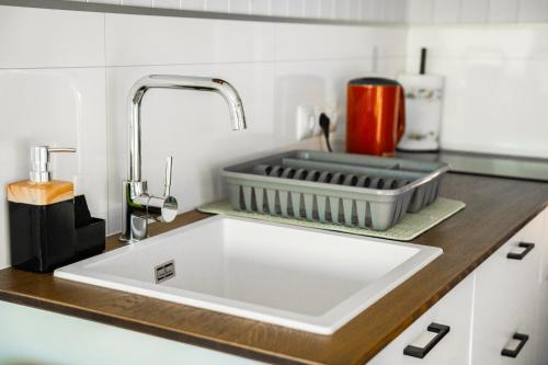 a kitchen counter with a white sink in a kitchen at Zajazd Józef Domki przy szlaku do Doliny Chochołowskiej i Lejowej, 850m od Doliny Kościeliskiej in Witów
