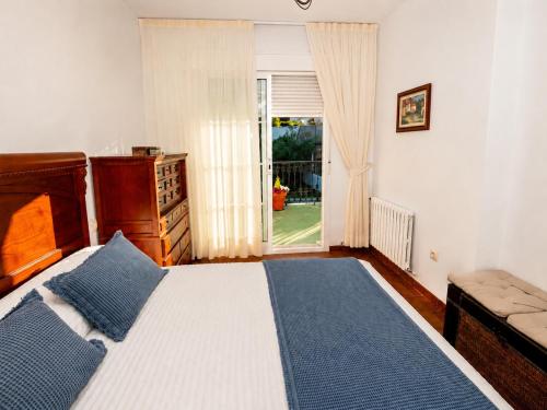 a bedroom with a bed and a dresser and a window at Casa Maruja O Grove in O Grove