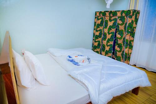 a white bed in a room with a curtain at KEFA Town Hotel in Kigali