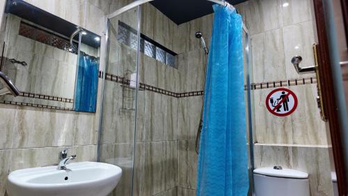 a bathroom with a shower with a sink and a toilet at The Quiet Corner Guest House in Maputo