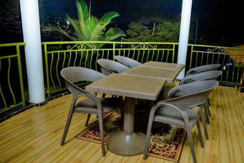 a wooden table and chairs on a balcony at KEFA Town Hotel in Kigali