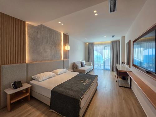 ein Hotelzimmer mit Bett und Fernseher in der Unterkunft Avaris Hotel in Dhërmi