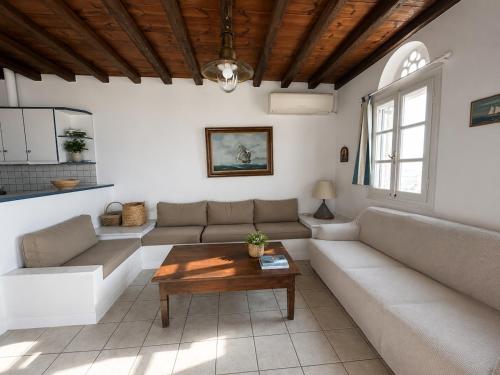 a living room with a couch and a table at Above the Blue in Agios Sostis