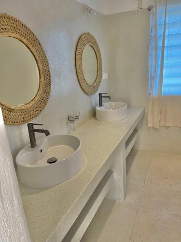 a bathroom with two sinks and mirrors on a counter at Deluxe room in Watamu