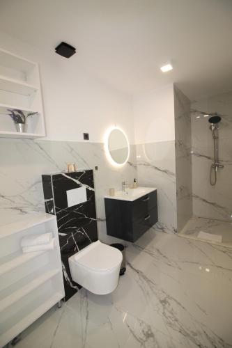 a white bathroom with a toilet and a sink at Villa New York in Novalja