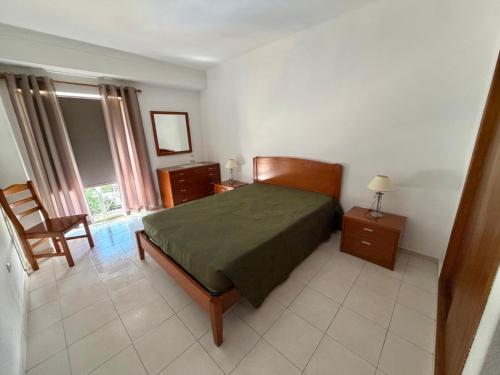 a bedroom with a bed and a chair in it at Edificio Caique C in Armação de Pêra