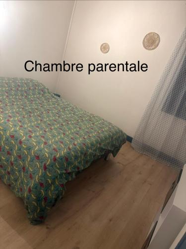 a bed in a room with the words champagne parachute at Maison confort ombragé 2 chambres in Amélie-les-Bains-Palalda