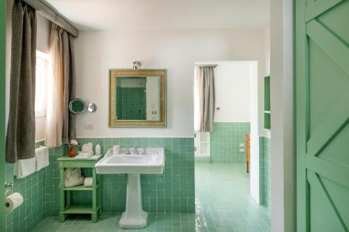 a green bathroom with a sink and a mirror at Santavenere Hotel - The Leading Hotels of the World in Maratea