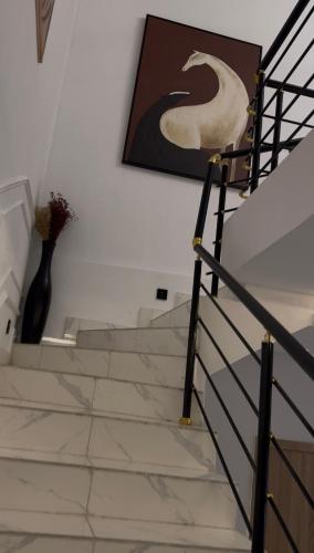 a staircase with a vase on the wall and a painting at ZEELUX Apartment in Ikuata
