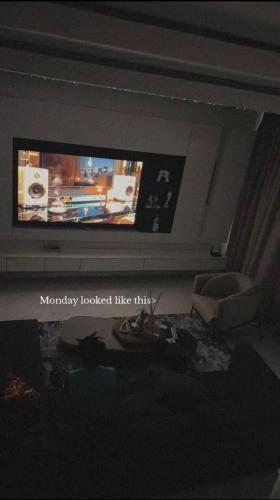 a living room with a flat screen tv on the wall at ZEELUX Apartment in Ikuata