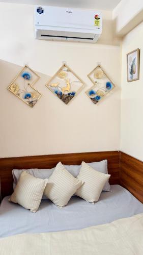 a bedroom with a bed with four pictures on the wall at Namma Suites cozy 1BHK Stay Near Koramangala BTM layout in Bangalore