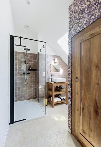 a bathroom with a shower with a glass door at Chambre d'hôtes Cocotte & Bigoudi in La Ferté-Beauharnais
