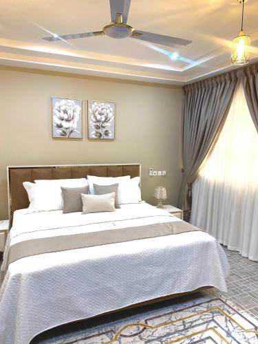 a bedroom with a large bed and a ceiling fan at Modern Three-Bedroom Apartment in Accra