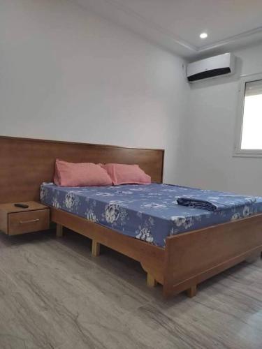 a bedroom with a large bed with a wooden frame at Dar saber in Sfax