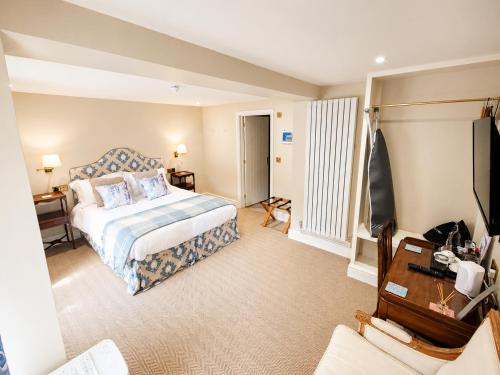 a hotel room with a bed and a television at The Fox at Ibstone in High Wycombe