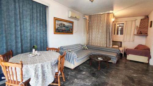 a living room with a table and a couch at Villa tusia in Vravrona