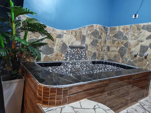 a bathroom with a large tub with a stone wall at Hotel Las Lomas de Pisco in Pisco