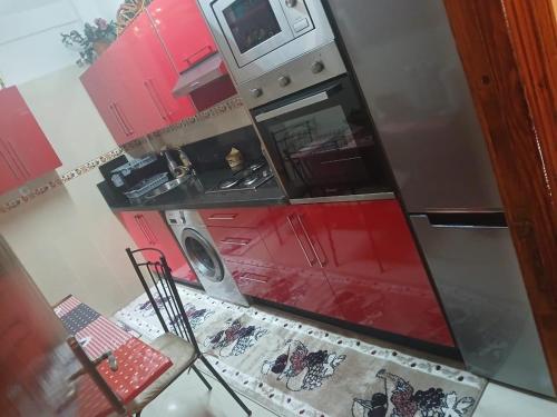 an overhead view of a kitchen with red cabinets at App de luxe sur complexe ATANMIYA de MARTIL in Martil