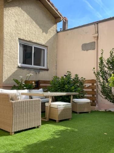 a patio with a table and chairs on grass at Cabane insolite avec jacuzzi in Menton