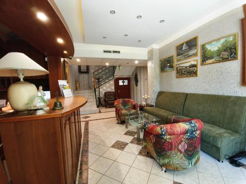a living room with a green couch and a table at Fortuna Hotel in Miskolctapolca