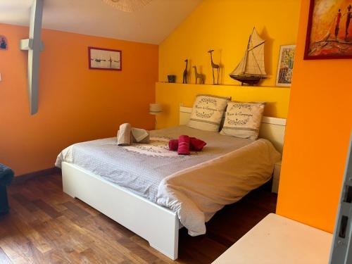 a yellow bedroom with a bed with two stuffed animals on it at Les Terrasses de Rostevel in Brech