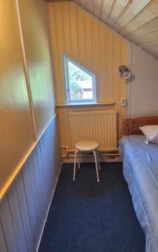 a room with a bed and a table and a window at Sundqvistens vinden in Emkarby