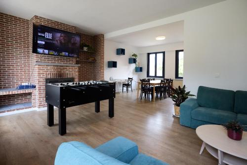 a living room with a ping pong table in front of a fireplace at De Ontspannerij in Lille