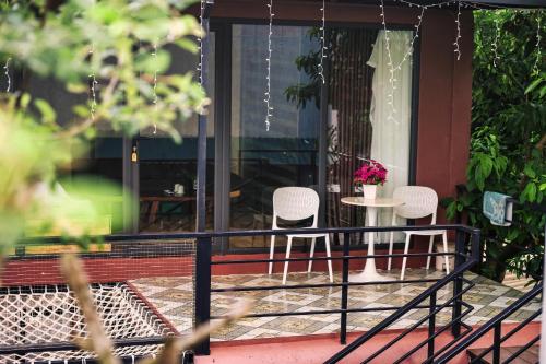 a porch with three chairs and a table with flowers at Tình's Homestay in Ninh Binh