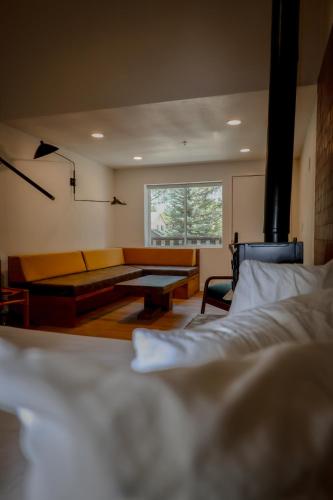 a living room with a table and a couch at Arkouda House in Big Bear Lake