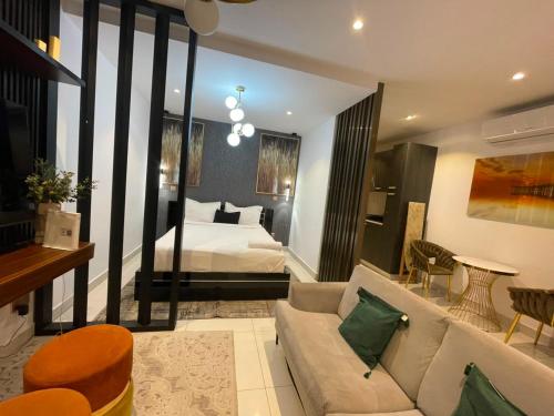 a living room with a couch and a bed in a room at The Lennox Premier Suites in Accra