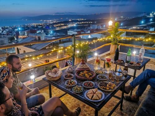 a table full of food on a balcony at night at Paradise House Apartment in Tamraght in Tamraght Ouzdar
