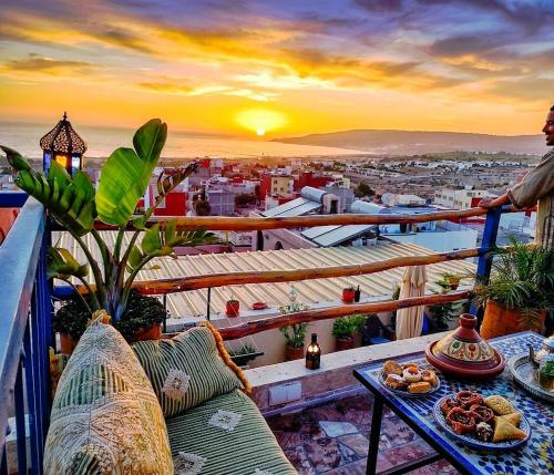 a person standing on a balcony with a table with food at Paradise House Apartment in Tamraght in Tamraght Ouzdar