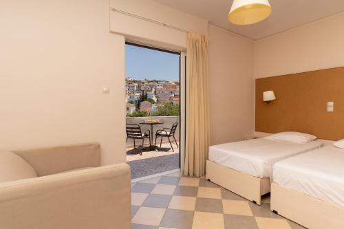 ein Hotelzimmer mit zwei Betten und Balkon in der Unterkunft Galaxy New Hotel in Pylos